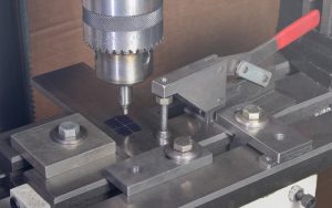 What should be noted in the determination of the workpiece clamping method in CNC machining?